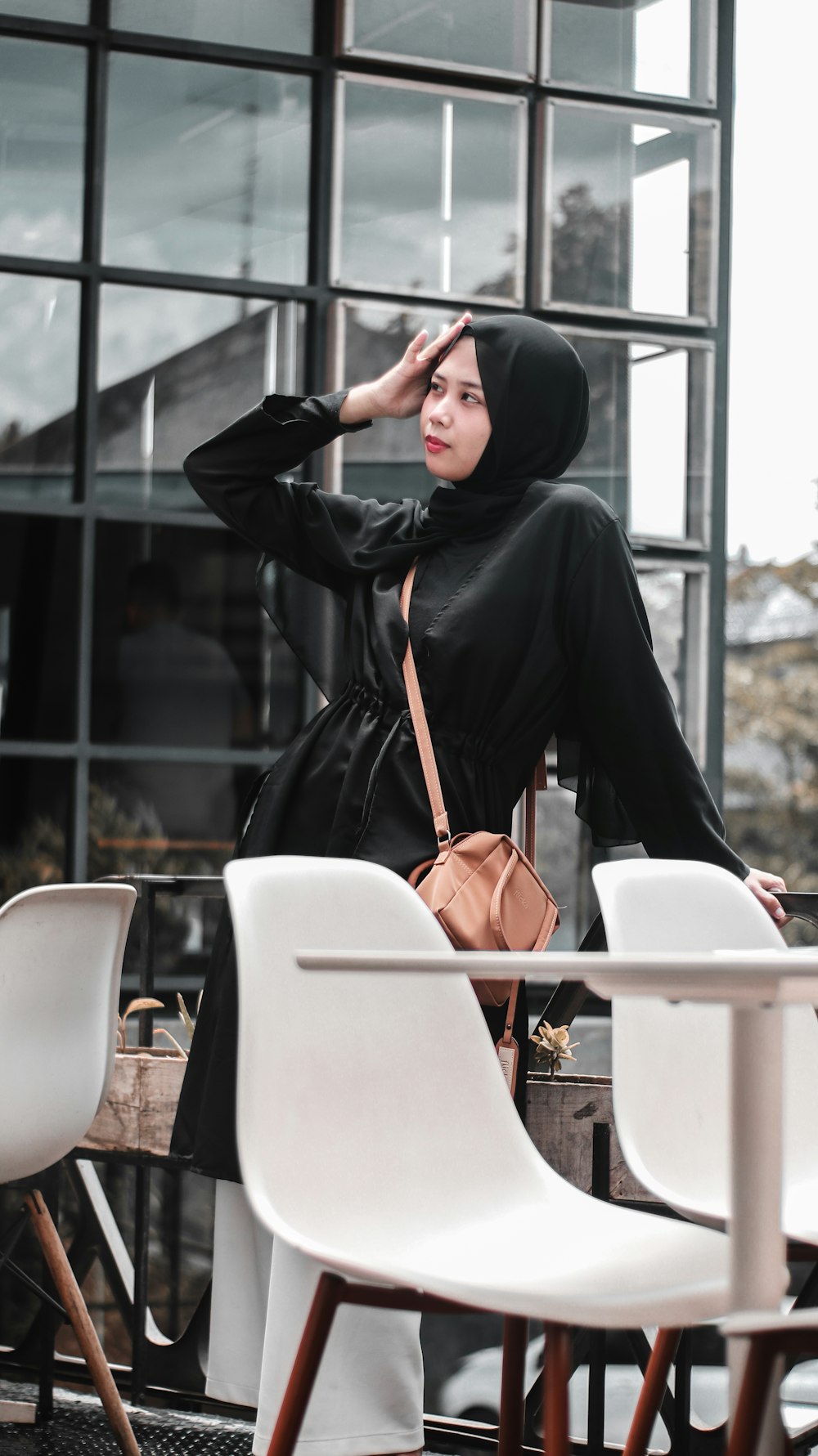 woman in black hijab and abaya sitting on white chair