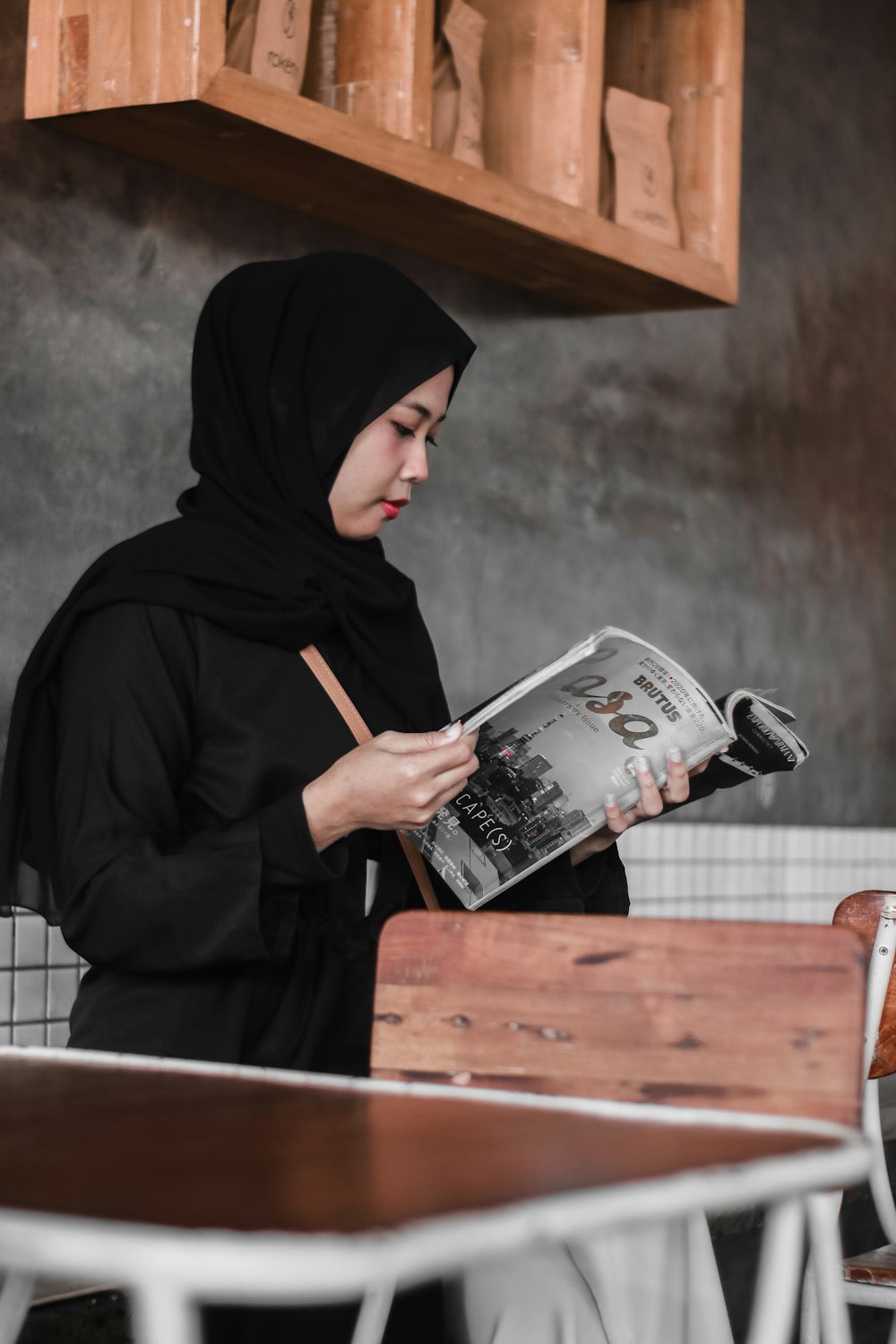 person in black hoodie holding white and black book