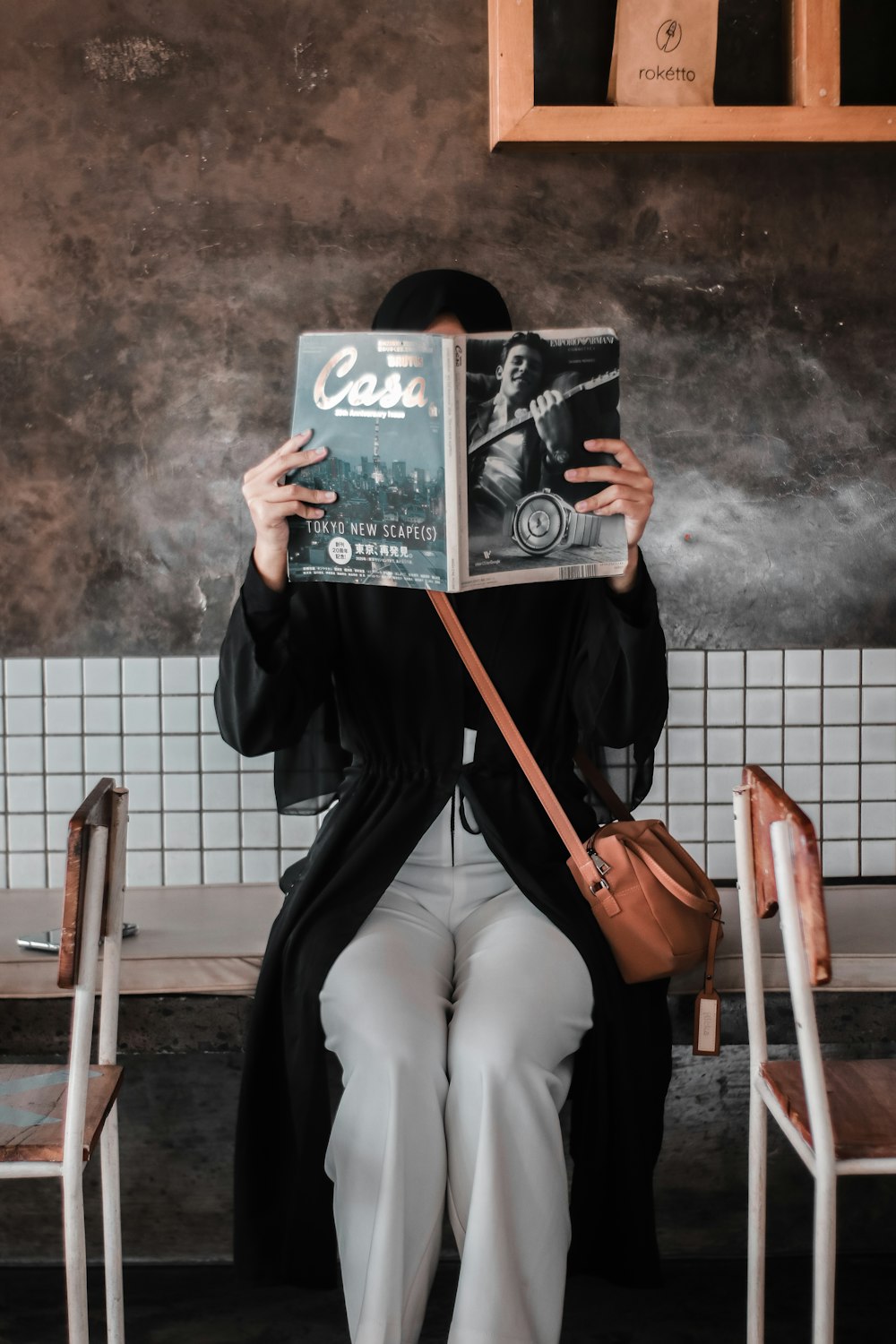 person in black jacket holding book