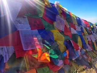 A vibrant display of colorful worship flags gently waving in a sunlit room.