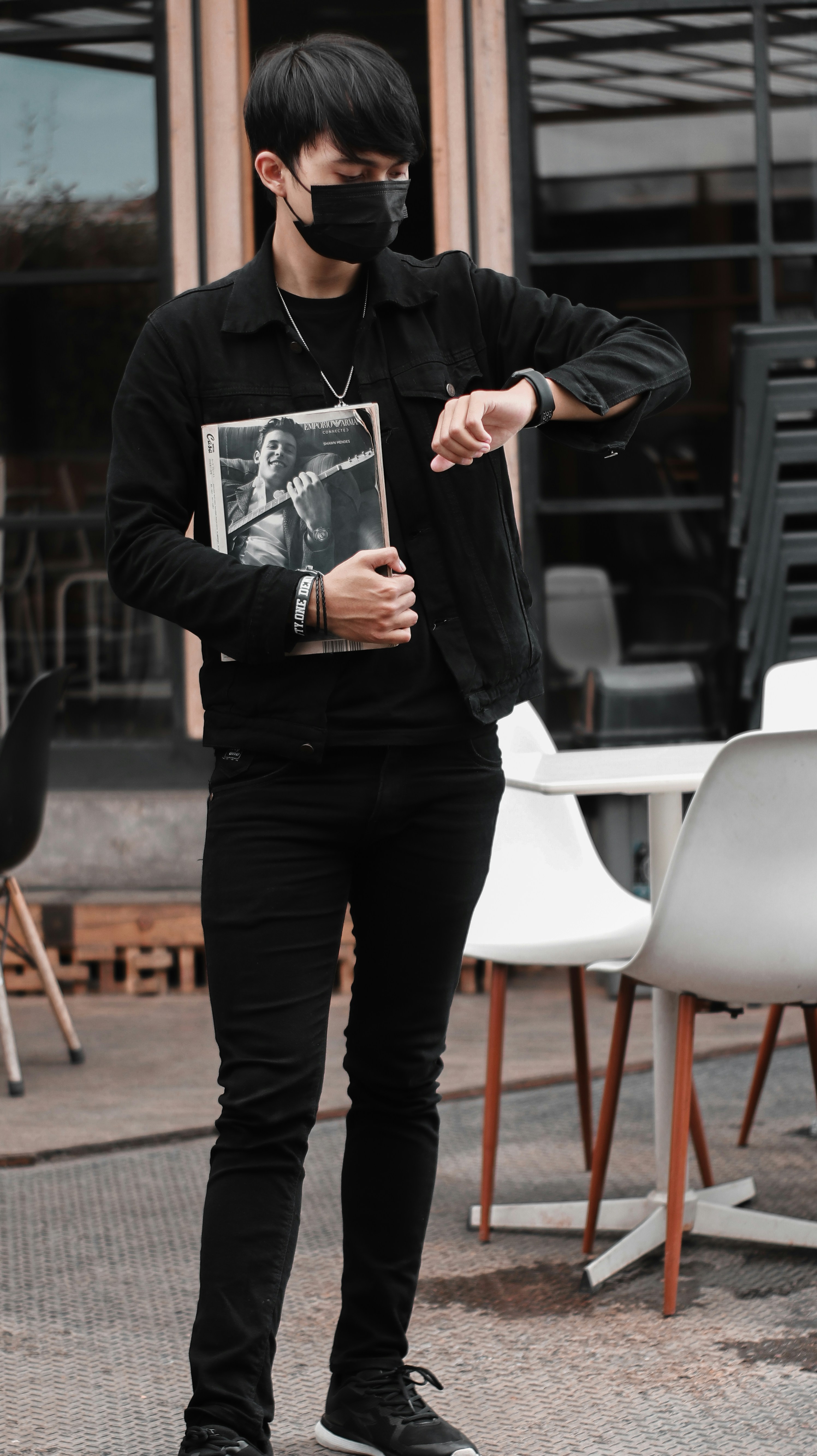 man in black dress shirt and black pants holding black smartphone