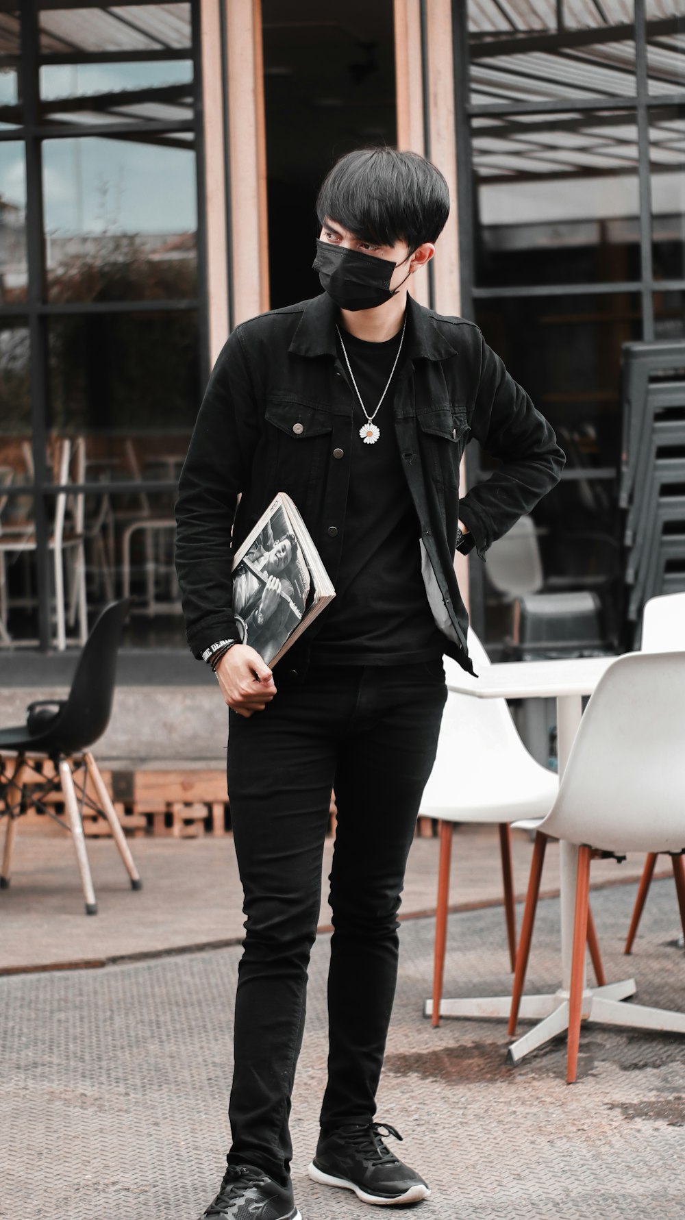 man in black leather jacket holding a book