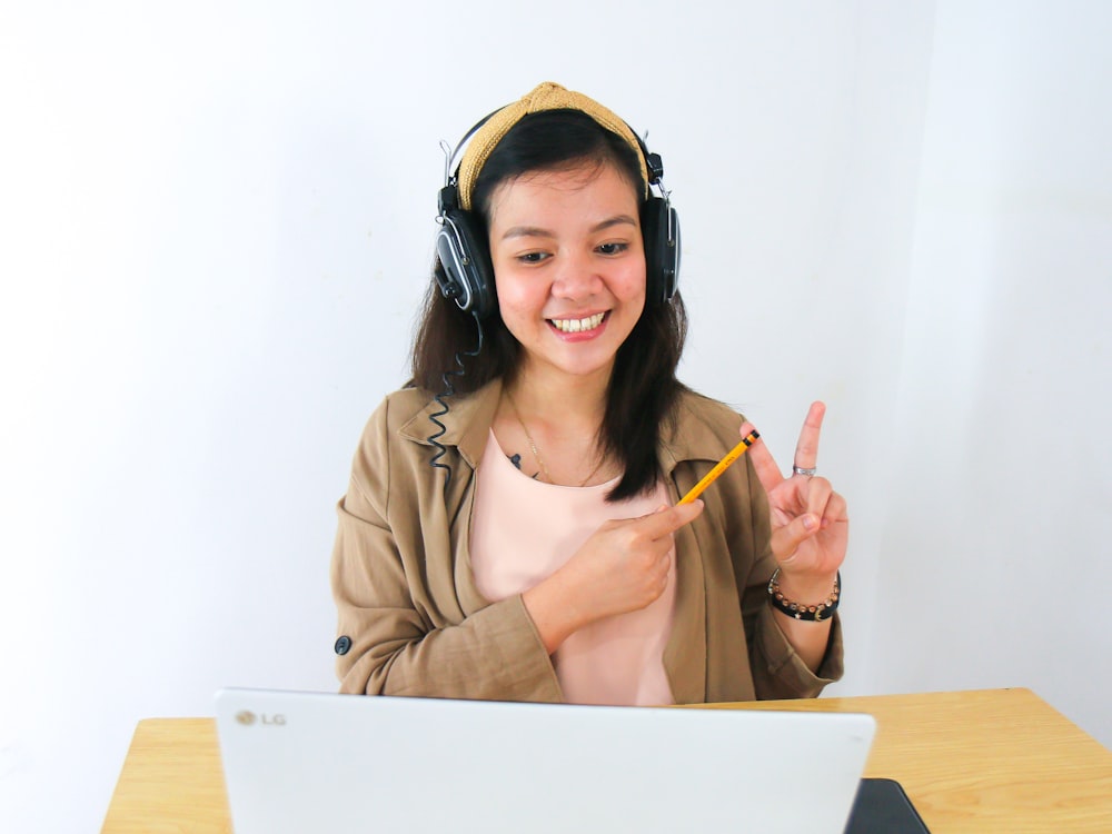 woman in brown blazer wearing black headphones