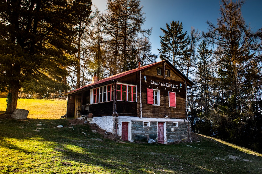 Braunes und weißes Holzhaus in der Nähe von grünen Bäumen tagsüber