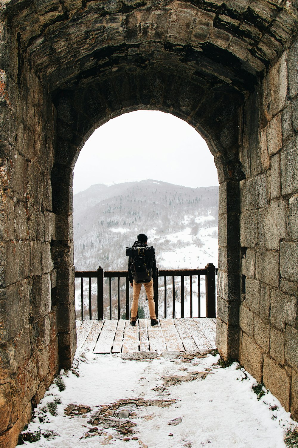 낮 동안 갈색 나무 부두에 서 있는 검은 드레스를 입은 여자