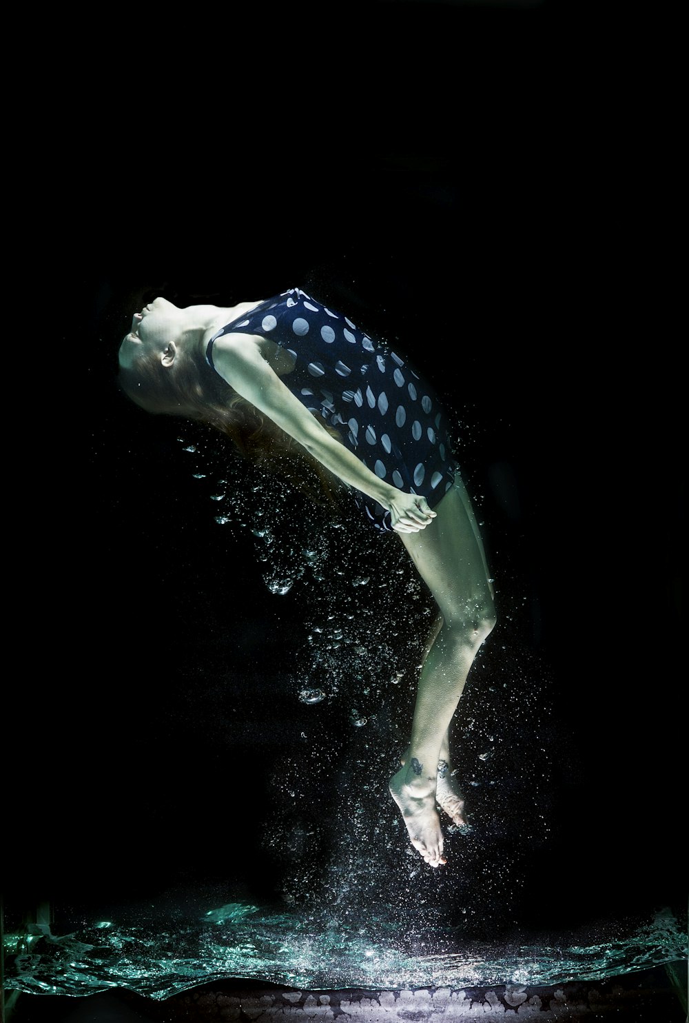 mulher no biquíni azul e branco das bolinhas na água