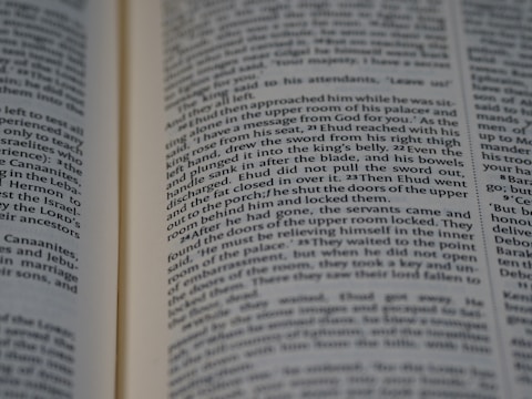 An open book with printed text. The focus is on two pages filled with paragraphs, with the text aligned in columns. The font is small and the page edges are slightly visible, suggesting it might be a religious or historical text.