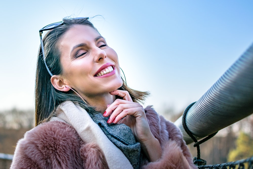 mujer sonriente en abrigo de piel marrón