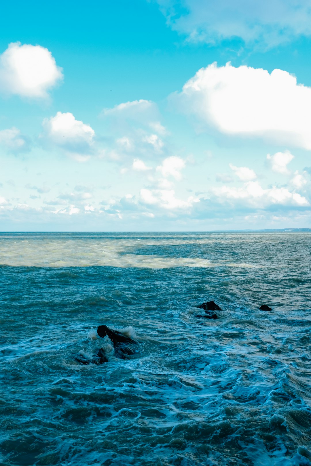 sea waves crashing on shore during daytime