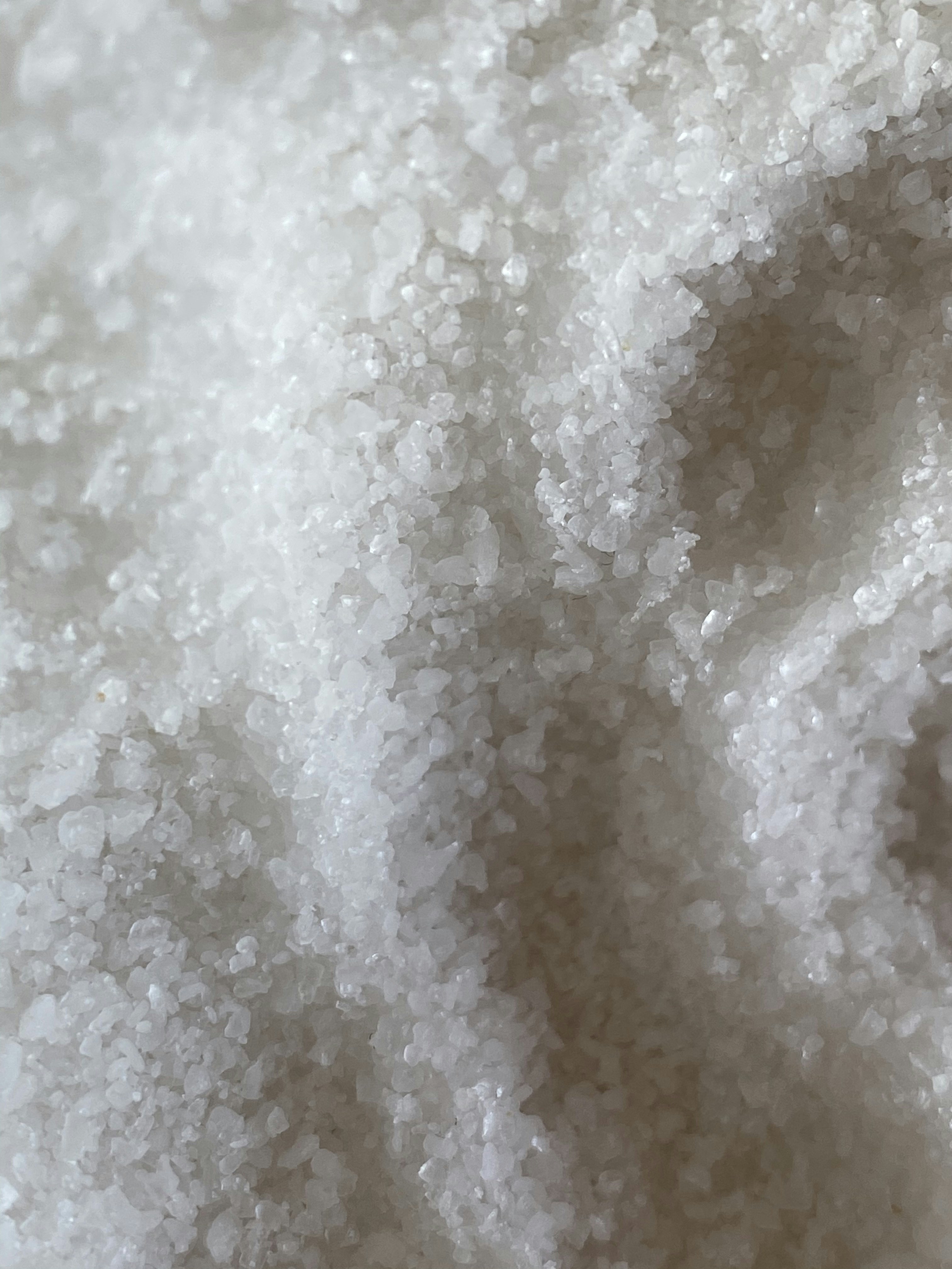 Kripë natriumi e bardhë e kristalizuar mbi sfond të errët, ndriçim i butë