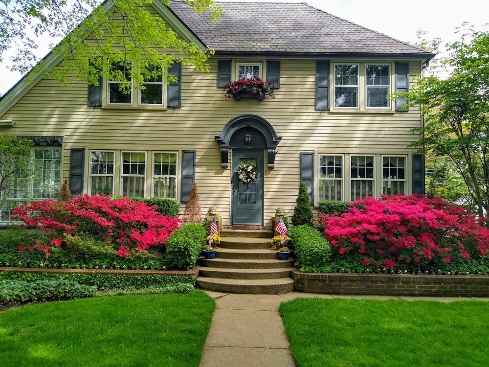 Casa de hormigón gris con flores rojas en el lateral