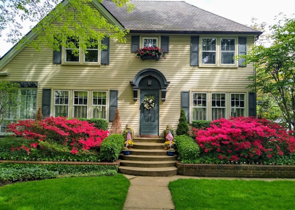 gray concrete house with red flowers on the side