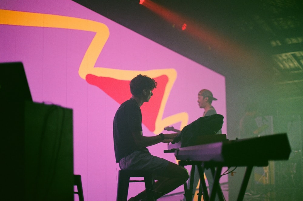 man in black long sleeve shirt playing piano