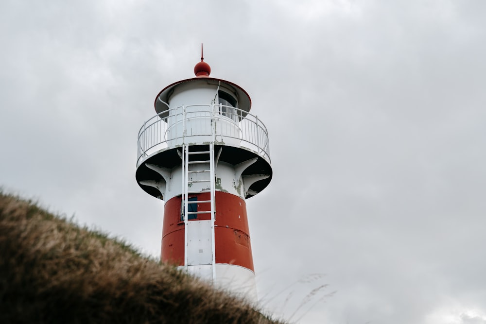 white and red lighthouse under cloudy sky during daytime