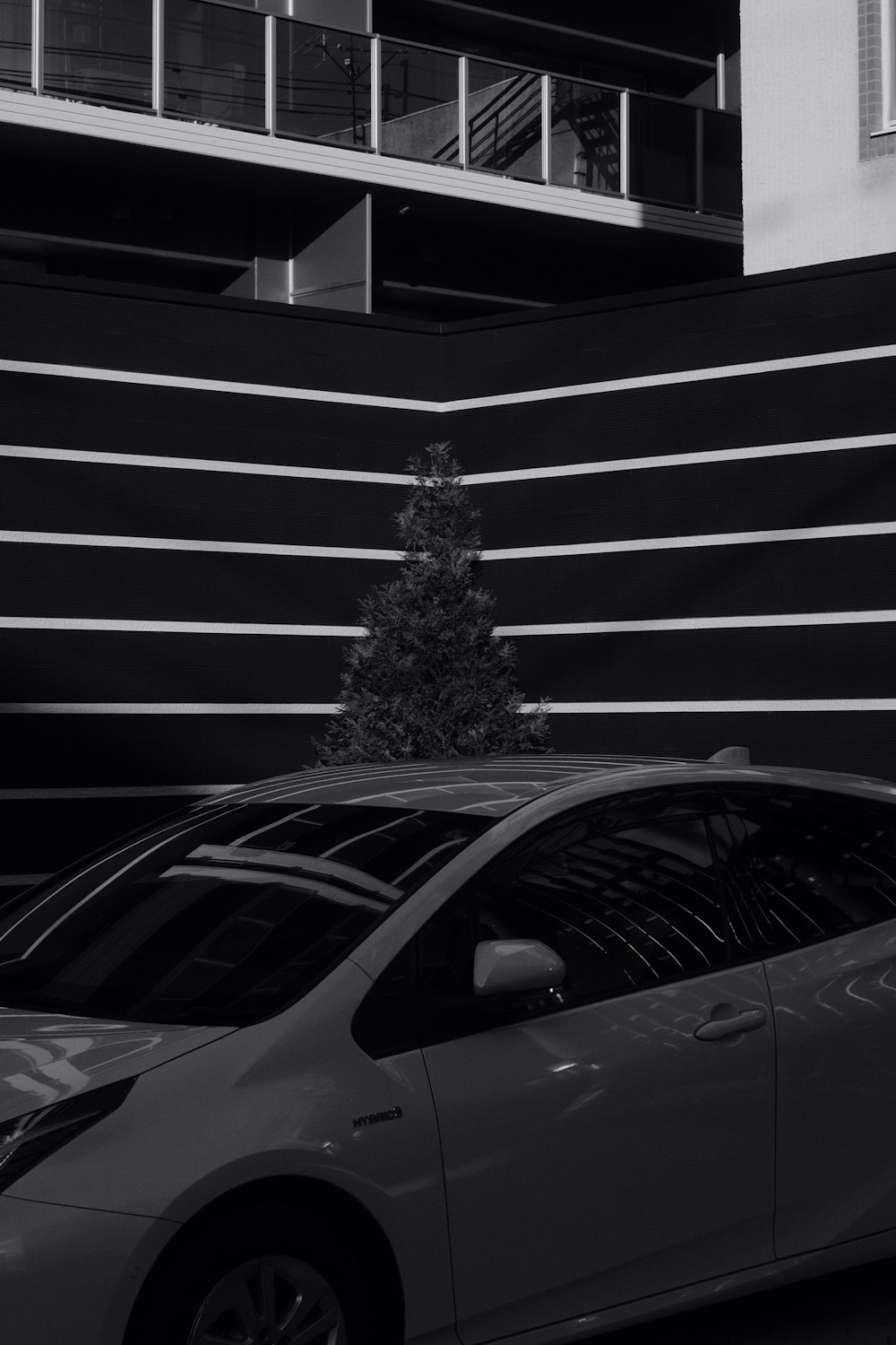 grayscale photo of car parked in front of building