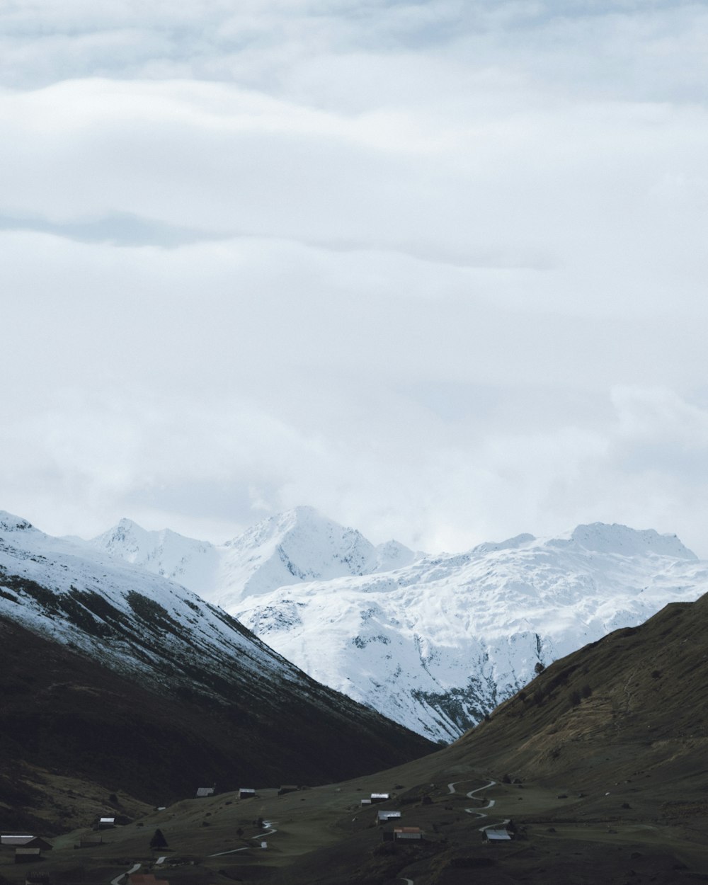 snow covered mountains under cloudy sky during daytime