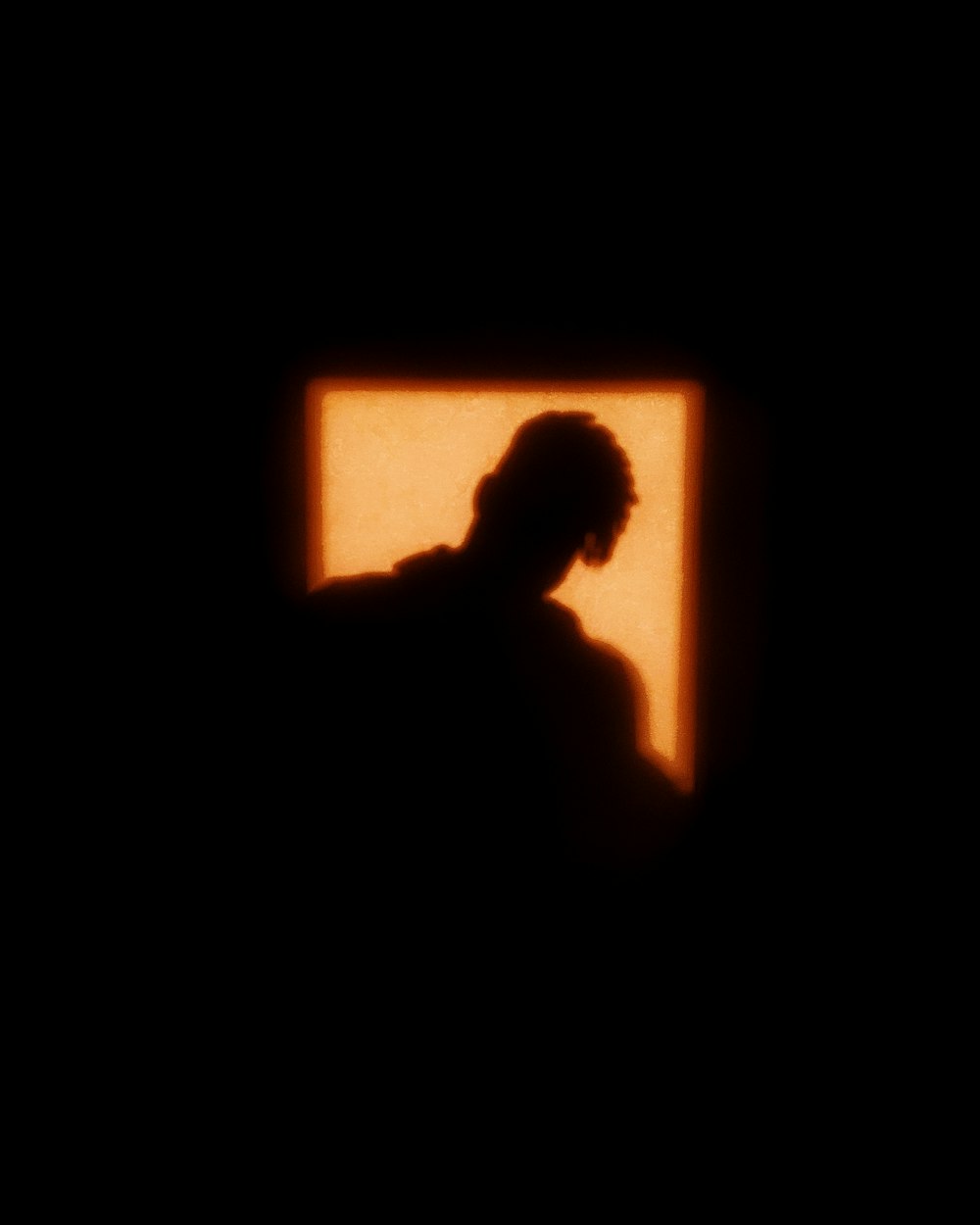 silhouette of man in front of window