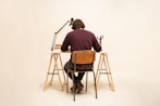 man in brown shirt sitting on brown wooden chair