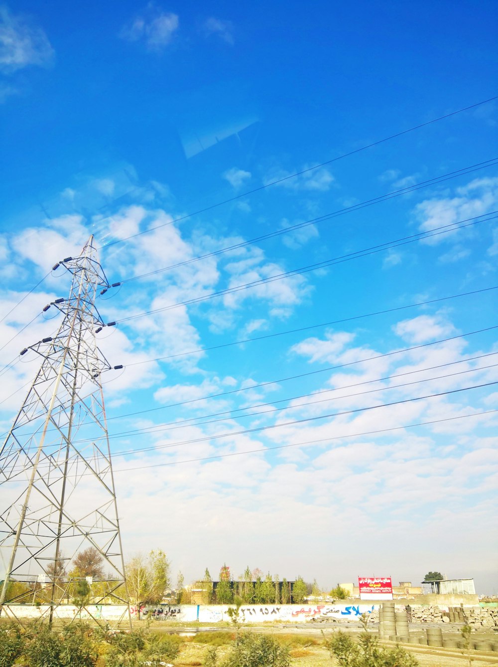 white metal electric tower under blue sky during daytime