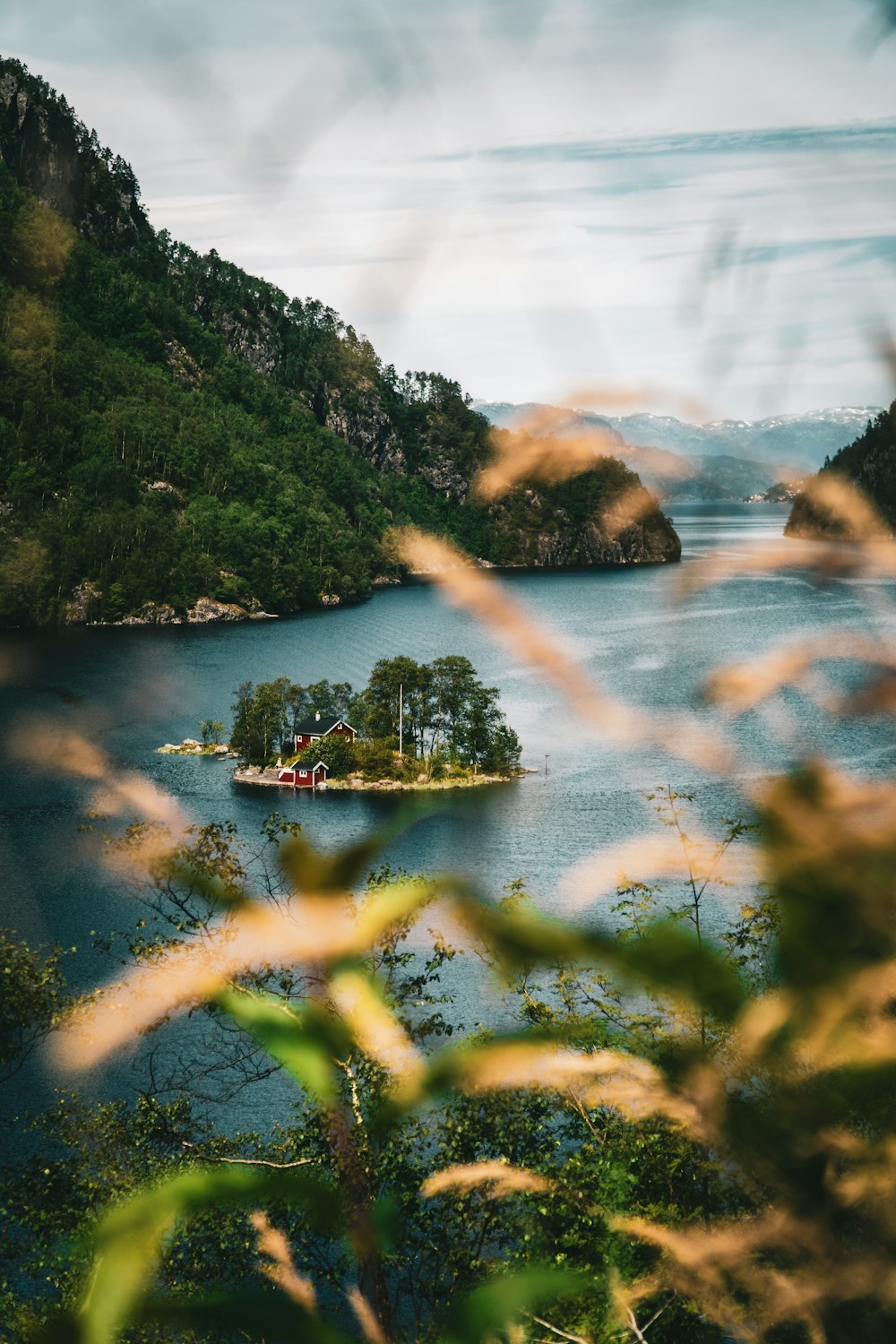 green mountain beside body of water during daytime