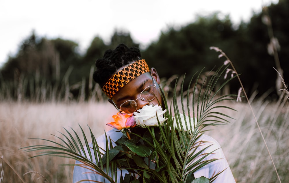 woman in white long sleeve shirt holding white and pink flower