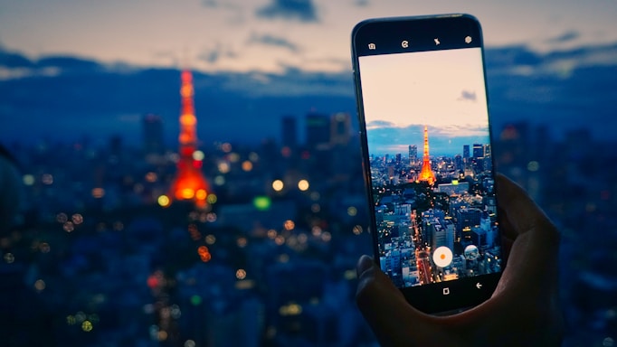 A sleek smartphone displaying the Vupe app interface with a cityscape background at dusk.