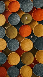 Colorful woven baskets arranged artistically on a natural fiber cloth.