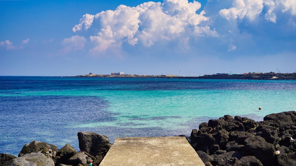 blue sea under blue sky and white clouds during daytime