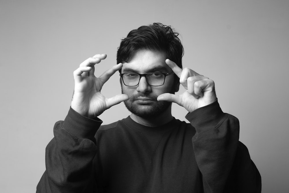 man in black long sleeve shirt wearing black framed eyeglasses