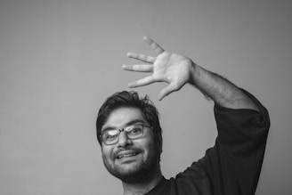 A casual friendly wave from a person standing in front of a minimalist website screen.