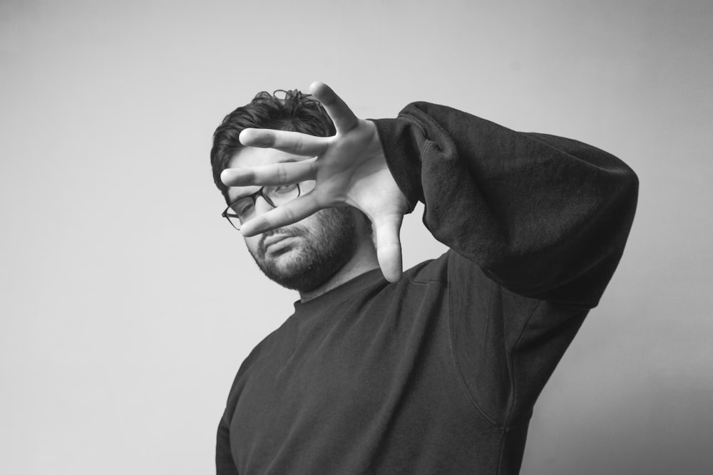 man in black crew neck shirt covering his face