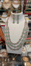 Display of several golden necklaces arranged elegantly with vibrant colors in the background.