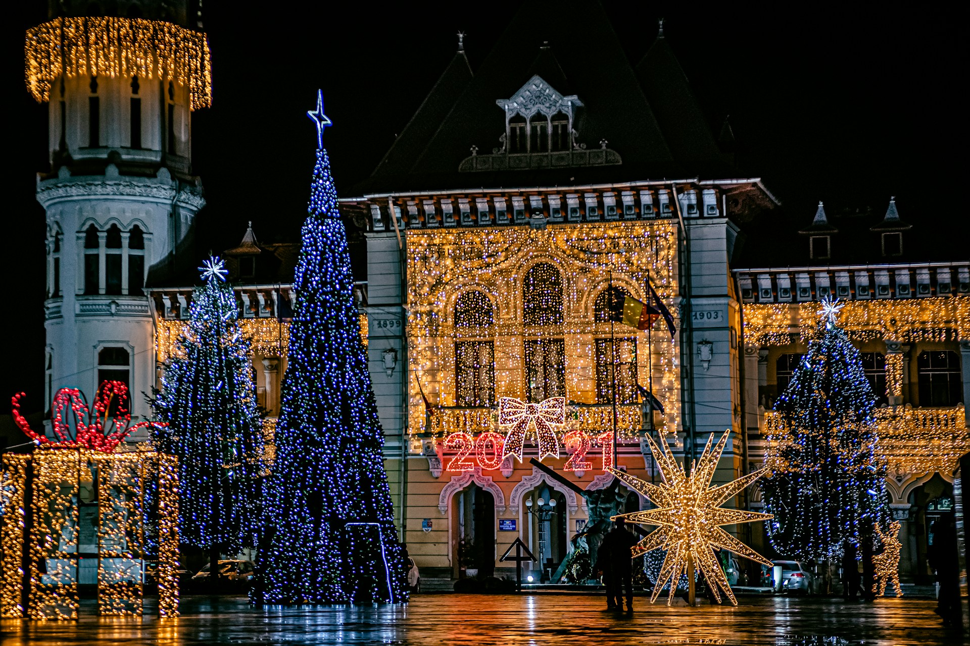 A warmly lit historic Kress building adorned with colorful Christmas lights and decorations, bustling with families and children enjoying the festive atmosphere.