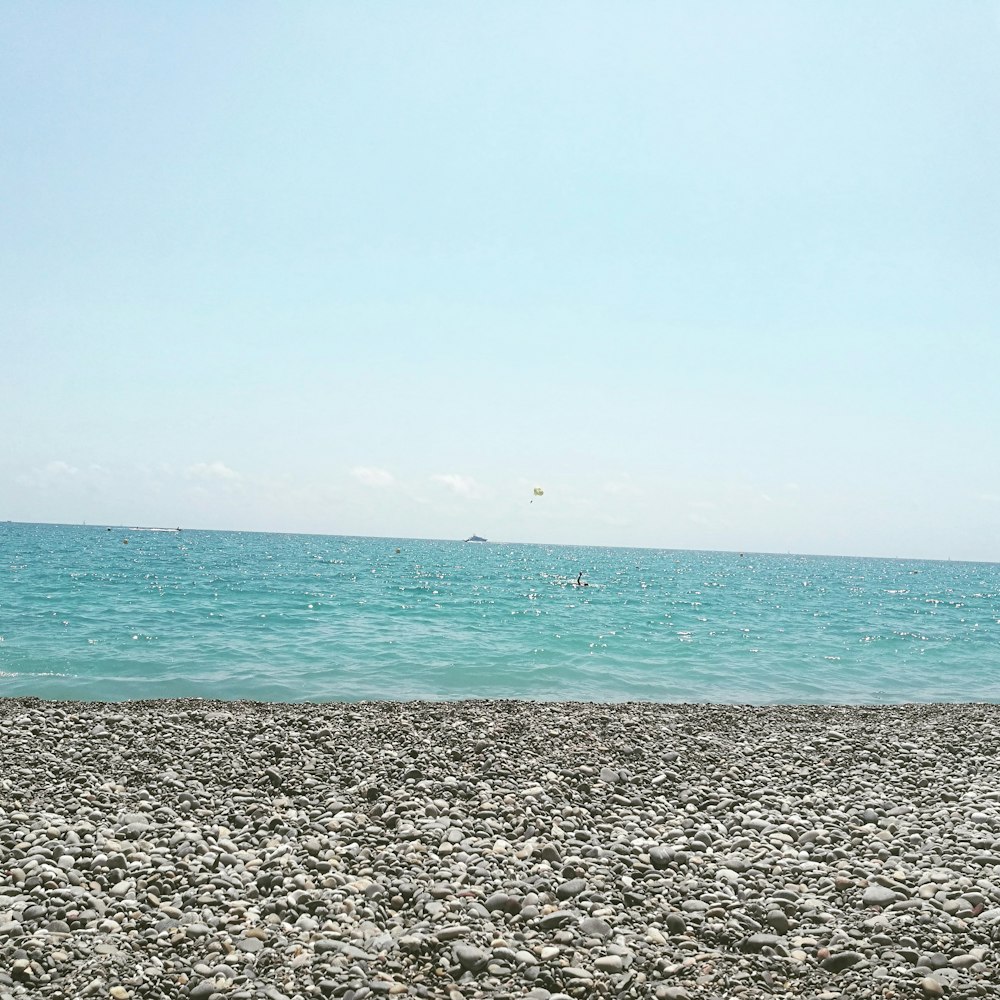 gray sand near body of water during daytime