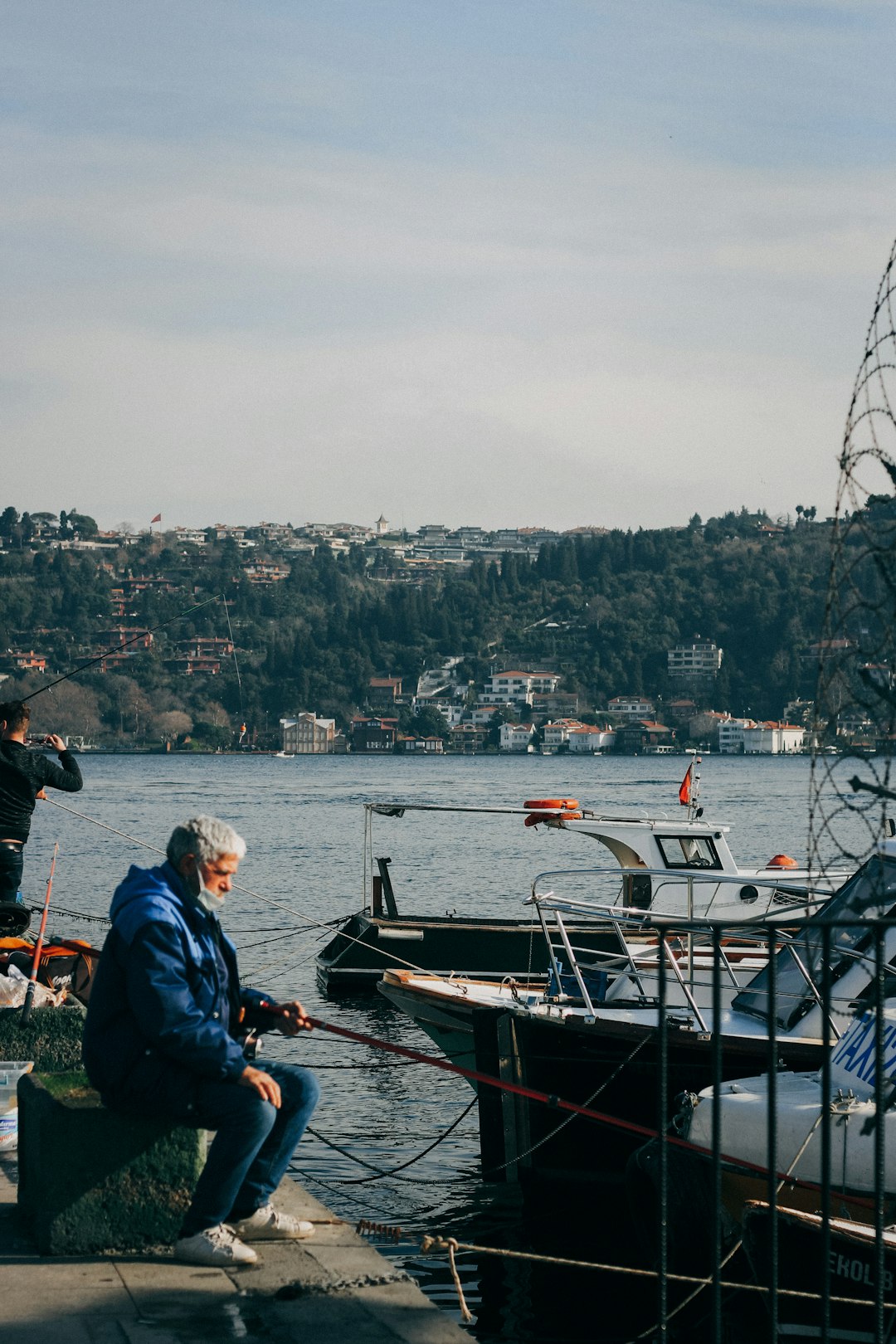 man in blue jacket sitting on boat during daytime