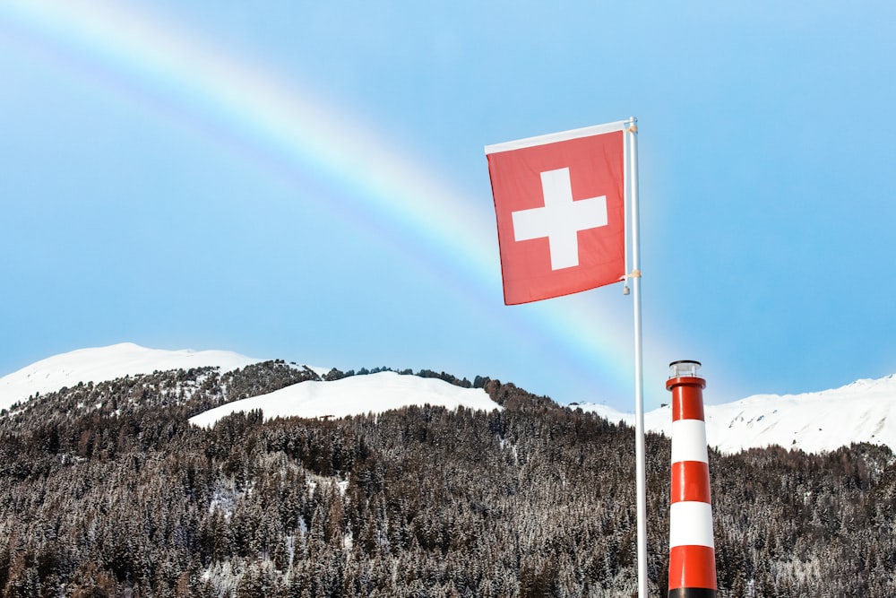 red and white cross flag on top of mountain