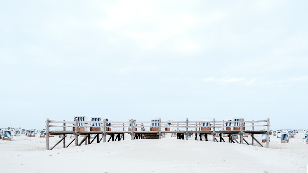 brown wooden beach chairs on white sand during daytime