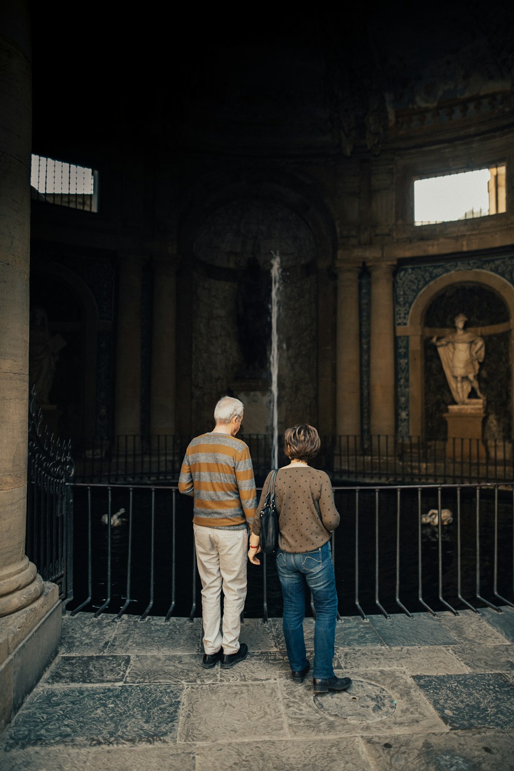 man and woman standing in front of black metal gate