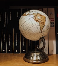 white and brown desk globe on brown wooden table