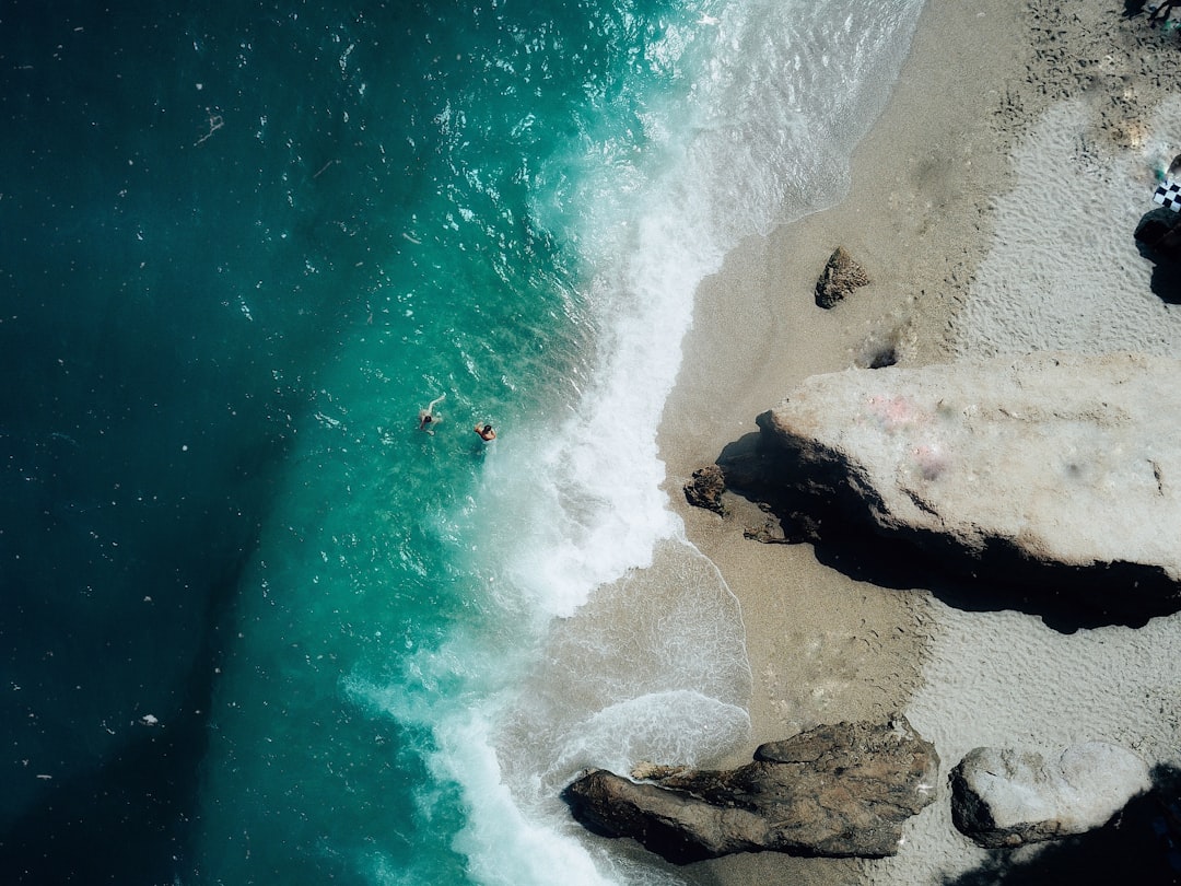 people surfing on sea waves during daytime