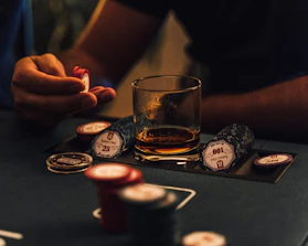 A hand holding casino chips with a glowing bonus sign in the background.