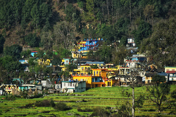 A vibrant traditional Myènè village scene with colorful houses and people in cultural attire.