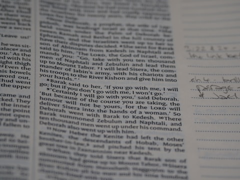 A page from a book with text in printed columns, discussing a biblical passage. There are handwritten notes on the right side in pen, adding personal annotations to the printed material.