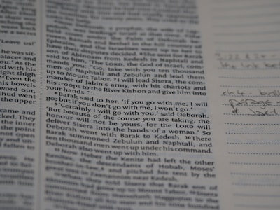 A page from a book with text in printed columns, discussing a biblical passage. There are handwritten notes on the right side in pen, adding personal annotations to the printed material.
