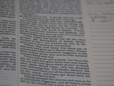 Several columns of printed text in a book are shown in focus, with a section of ruled lines on the right side of the image.