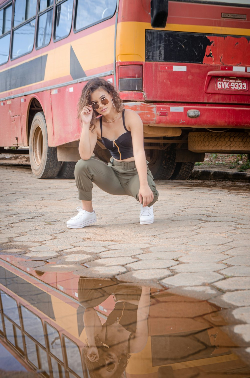 woman in gray tank top and gray pants sitting on brown wooden bench