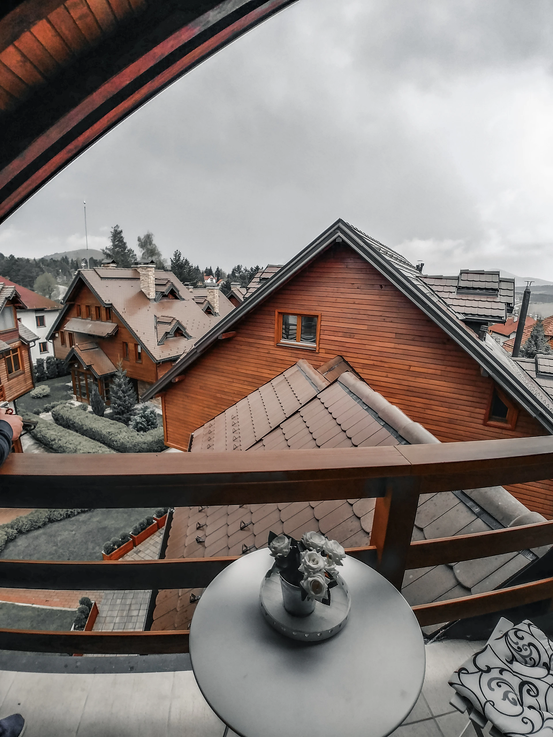 A cozy wooden balcony at Rabbit House Homestay overlooking misty mountain peaks at sunrise.