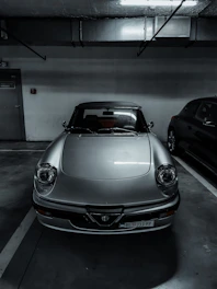 A pristine vintage sports car parked inside a spotless, well-lit storage facility.