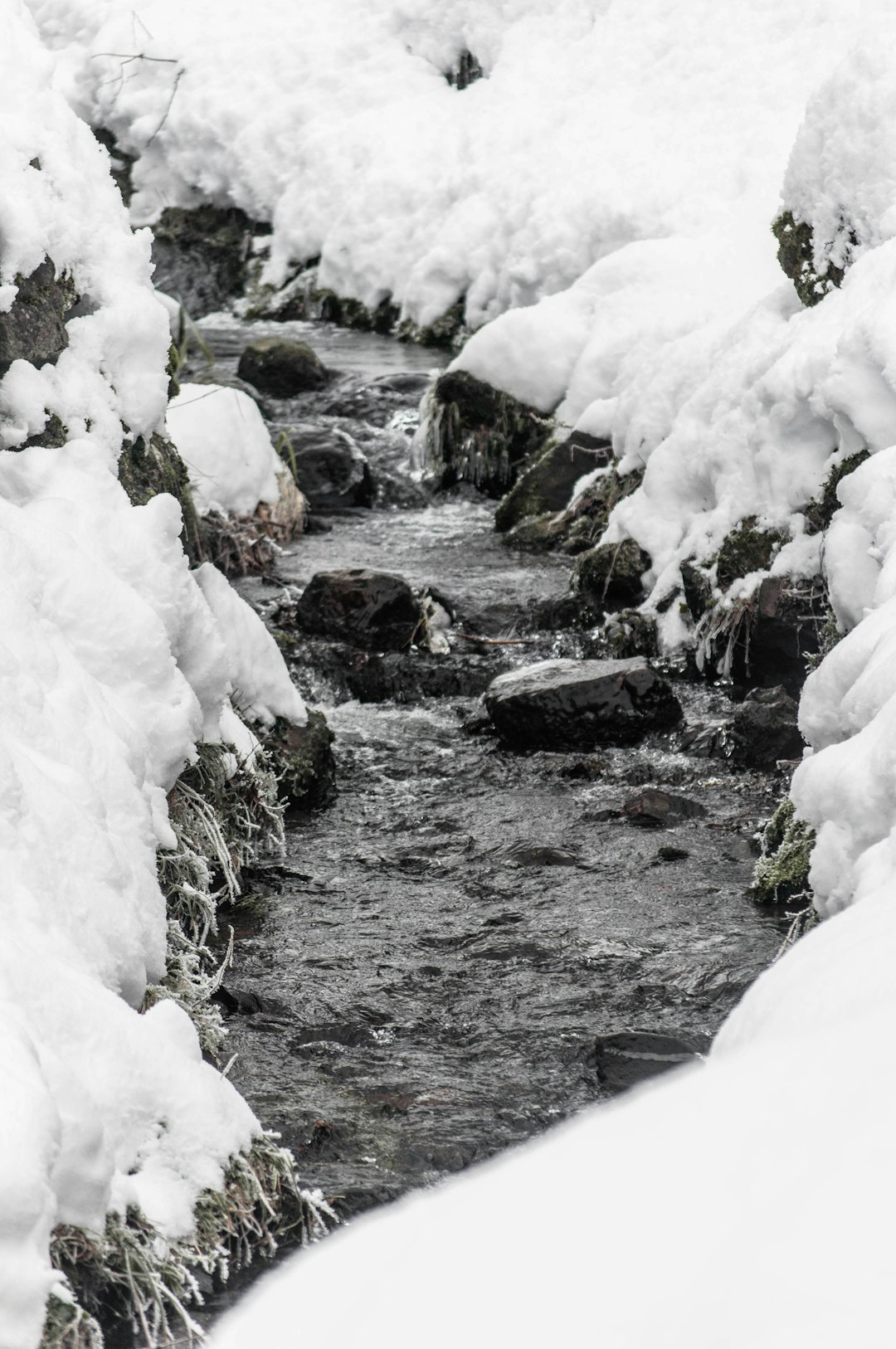 snow covered rocks and river