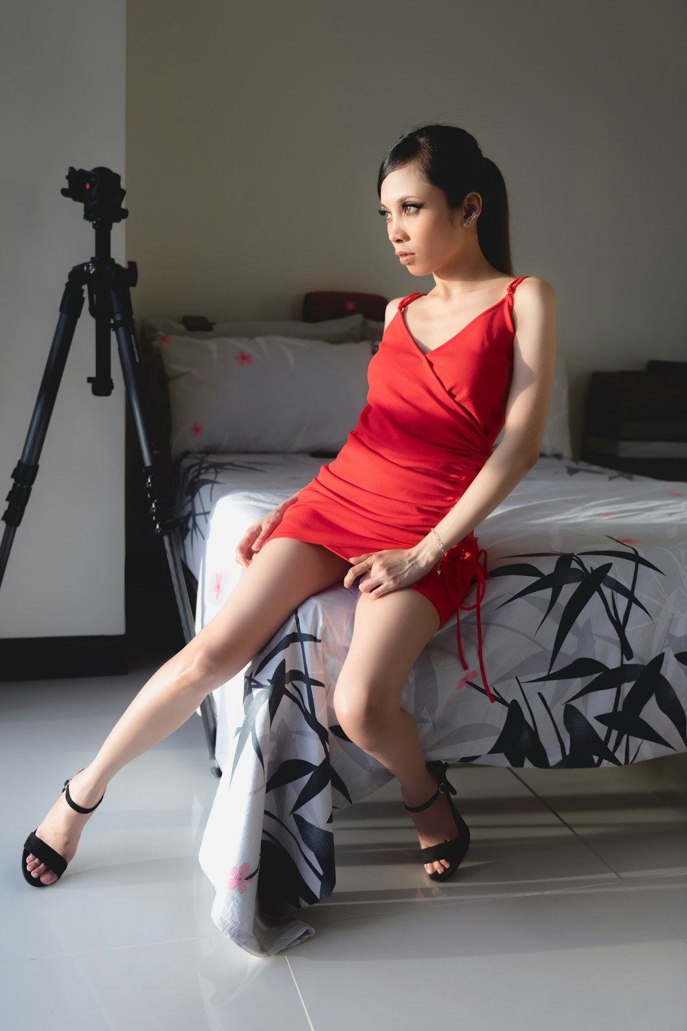 woman in red tank top sitting on white bed